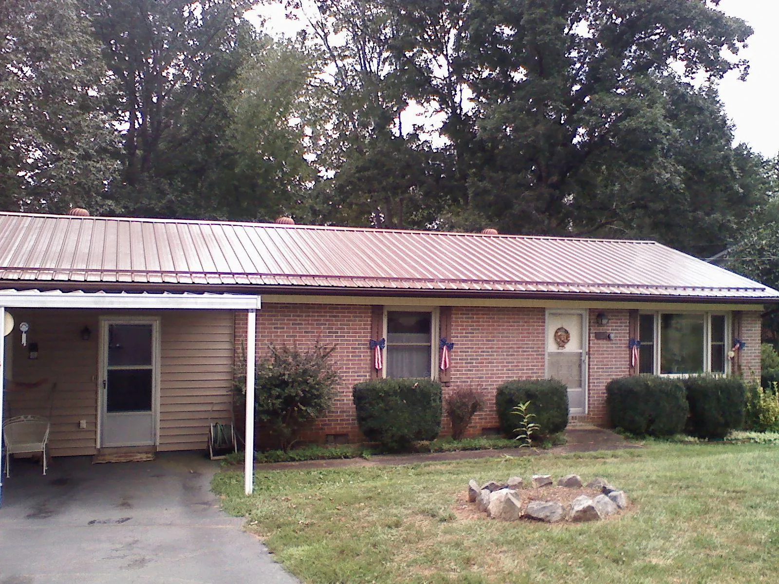 Bronze metal roof and carport on a brick ranch home — Roof Repair work by our crew in Fentress
